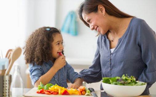 Picture of a mother with daughter (6-7 years old) preparing food in kitchen
